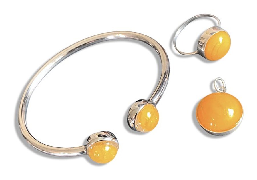 A bezel set cuff bracelet, ring and pendant with matching amber glass